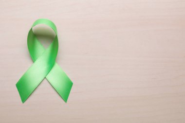 Dünya Akıl Sağlığı Günü. Ahşap arkaplanda yeşil kurdele, metin için boşluk ile üst görünüm