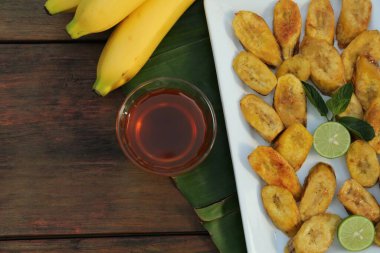 Düz kompozisyon ve ahşap masanın üzerinde kızarmış muz dilimleri vardı. Metin için boşluk