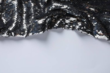 Beyaz arka planda güzel parlak pullu kumaş, üst manzara. Metin için boşluk