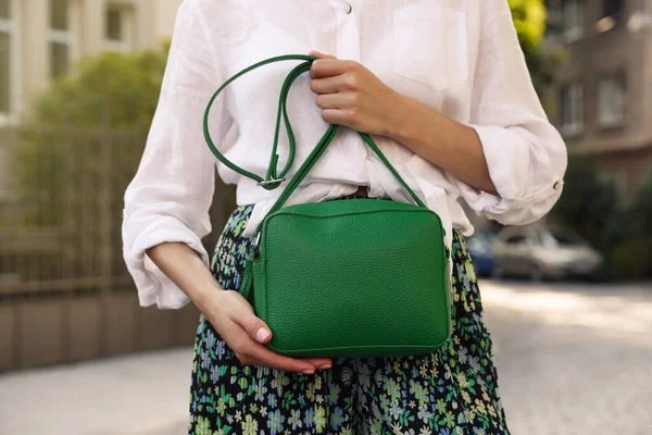 Woman with stylish green bag on city street, closeup