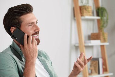 Evde telefonla konuşan yakışıklı bir adam, mesaj için yer var.