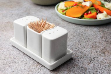 Tuz, biber ve kürdanlı tutucu gri masada. Metin için boşluk