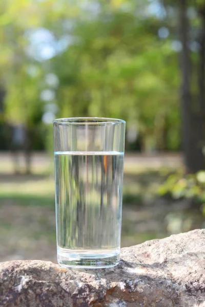 Glass of cool water on stone outdoors