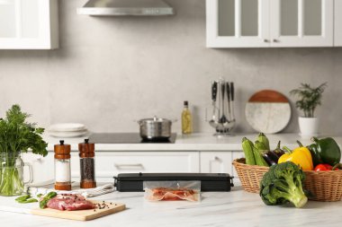 Süpürge ambalajı için mühür, beyaz mutfak masasında plastik torba içinde et.
