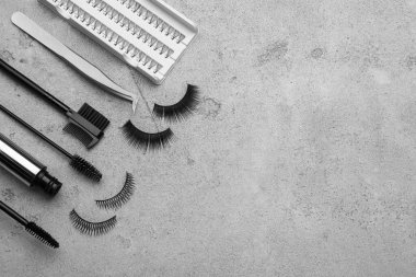Düz bileşim, takma kirpikleri ve açık gri arka planda aletleri vardı. Metin için boşluk