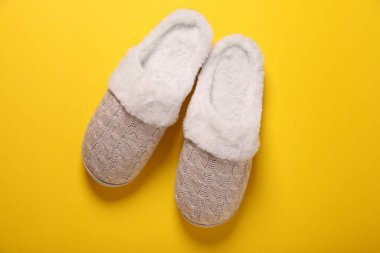 Sarı arka planda bir çift güzel yumuşak terlik, üst manzara.
