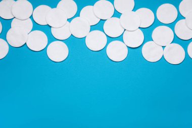 Açık mavi arka planda bir sürü pamuk pedi var. Metin için boşluk