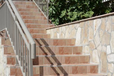 Güzel fayanslı merdivenler, dışarıda metal parmaklıklar var.