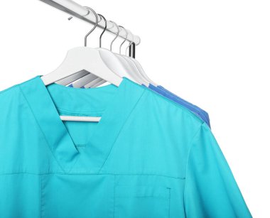 Turkuaz ve açık mavi üniformalar beyaz arka plana karşı rafta.