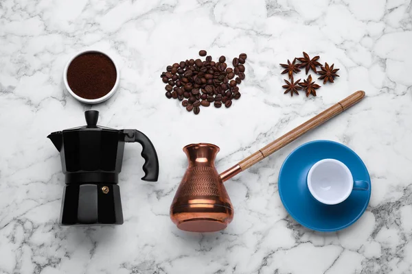 Flat lay composition with geyser coffee maker and roasted beans on white marble table