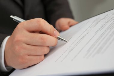 Ofisteki masada imza atan adam, yakın plan.