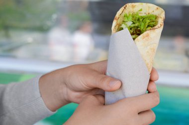 Nefis sebzeli dürüm tutan kadın, yakın plan.