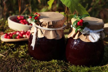 Kavanozlar dolusu lezzetli yaban mersini reçeli ve açık havada kırmızı böğürtlen
