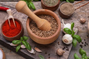 Havan topu ve ahşap masa üzerinde farklı baharatlar, üst görünüm