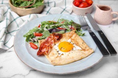 Beyaz mermer masada servis edilen yumurtalı leziz krep. Breton galeti