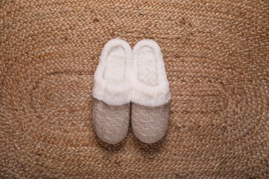 Hasır halıda güzel yumuşak terlikler, üst manzara.