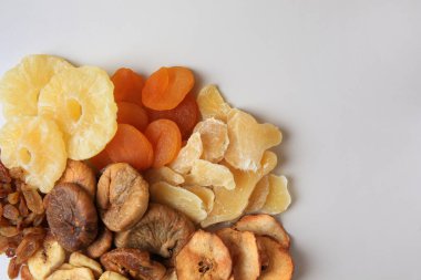 Beyaz arka planda farklı kurumuş meyveler yığını, üst manzara. Metin için boşluk