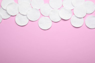 Pembe arka planda yumuşak, temiz pamuk pedleri, düz yatış. Metin için boşluk