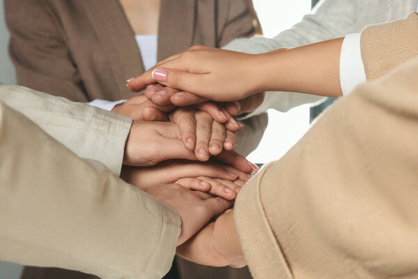 Group of people holding hands together indoors, closeup. Unity concept