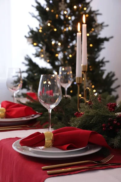 Beautiful place setting with Christmas decor on table indoors