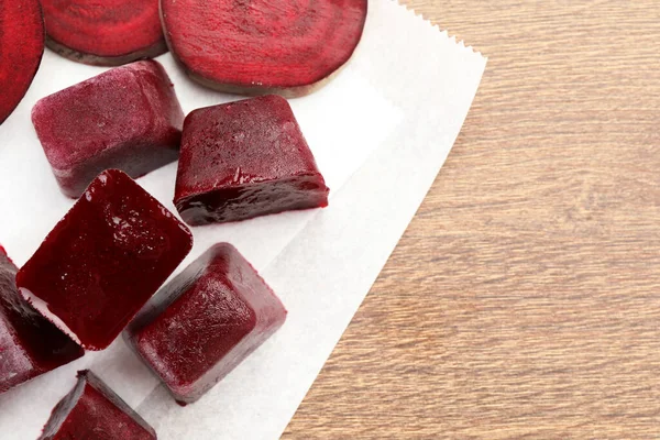 Frozen beetroot puree cube and fresh beetroot on wooden table, top view. Space for text