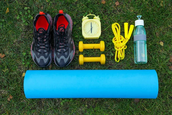 Set for morning exercise on green grass, flat lay
