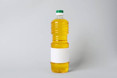 Açık gri arka planda bir şişe yemek yağı