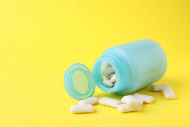 Sarı arka planda sakız çiğneyen kavanoz. Metin için boşluk