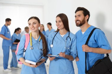 Üniversite koridorunda üniforma giyen tıp öğrencileri.