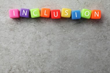 Açık gri arkaplanda kelime içerikli renkli küpler, düz bir zemin. Metin için boşluk