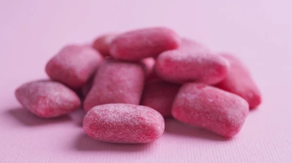 Heap of tasty sweet chewing gums on pink background, closeup