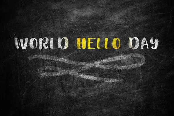 Phrase World Hello Day written on black chalkboard