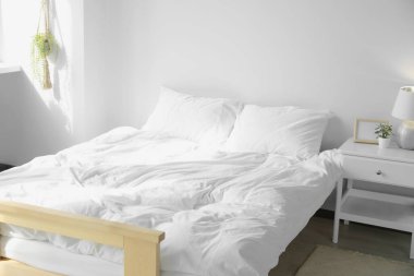 Yumuşak yastıkları ve battaniyesi olan büyük, rahat bir yatak.