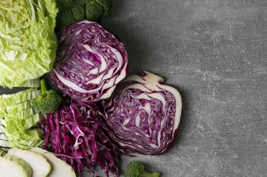 Gri masa üzerinde farklı kesim lahana türleri, düz yatıyordu. Metin için boşluk