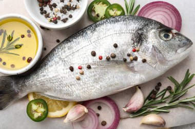 Taze dorado balığı ve baharatlar beyaz masada, düz yatıyordu.