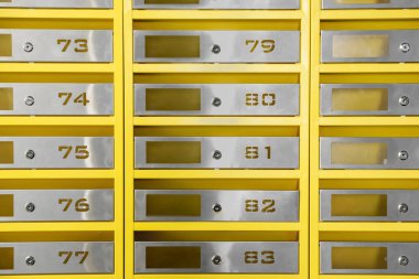 Many closed metal mailboxes with keyholes and numbers as background clipart