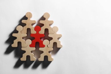 Beyaz arkaplandaki ahşap figürler arasında kırmızı figür, düz yatıyordu, yazı için yeri vardı. Asker arama çalışanı