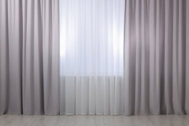 Açık gri pencere perdeleri ve beyaz tüller.
