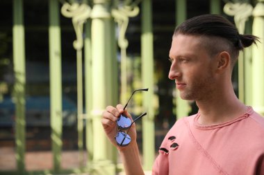 Dışarıda güneş gözlüklü yakışıklı bir adamın portresi, mesaj için yer.