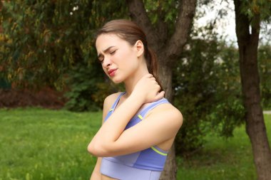 Genç kadın açık havada boyun ağrısı muzdarip