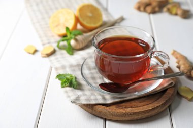 Bir fincan lezzetli zencefilli çay ve malzemeler beyaz ahşap masada, metin için yer var.