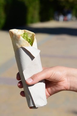 Nefis sebzeli dürüm tutan kadın, yakın plan.