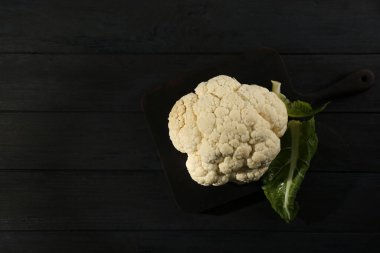 Siyah ahşap masada taze çiğ karnabahar, üst manzara. Metin için boşluk