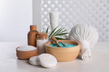 Beyaz ahşap masa üzerinde bakım ürünleri ile spa kompozisyonu