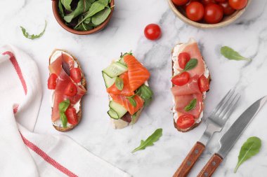 Beyaz mermer masa üzerinde servis edilen farklı lezzetli bruschetalar ile düz konum