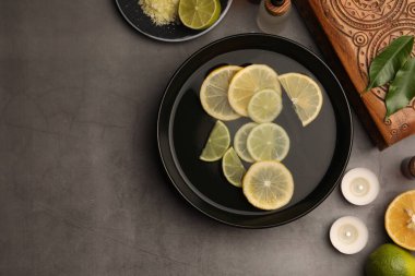 Yağ ve limon içeren düz bileşim gri masada, metin için boşluk. Aromaterapi tedavisi