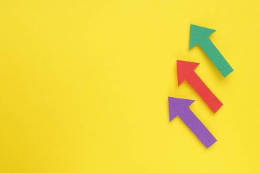 Sarı arka planda kağıt oklar, düz yatış. Metin için boşluk