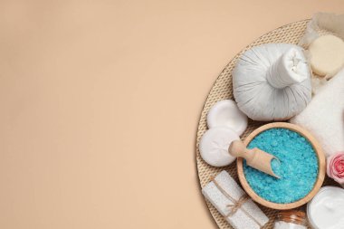 Bej arka planda bitkisel poşet ve spa ürünlerinin kompozisyonu, üst manzara. Metin için boşluk