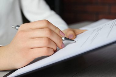 Ofisteki masada imza atan kadın, yakın plan.