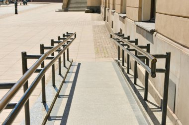 Rampası ve metal parmaklıkları olan açık hava merdivenleri.